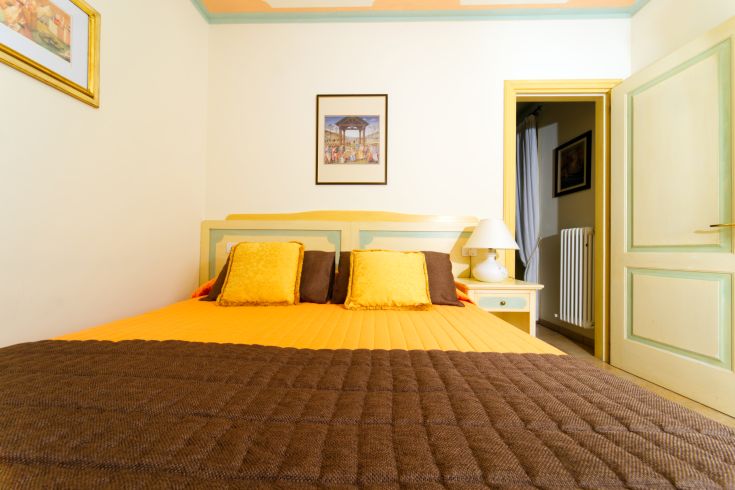 A simple bedroom with a double bed and vibrant decorations, ideal for relaxing moments.