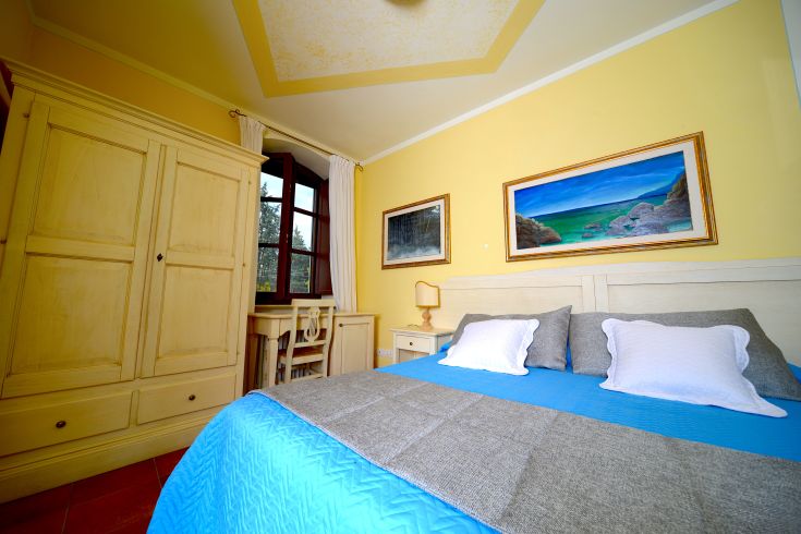 Cozy room with light furnishings and a peaceful view, perfect for a relaxing stay.