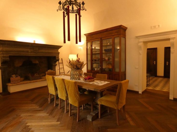 Appartamento accogliente con una zona pranzo ampia e un camino d'epoca, arredato con semplicità.
