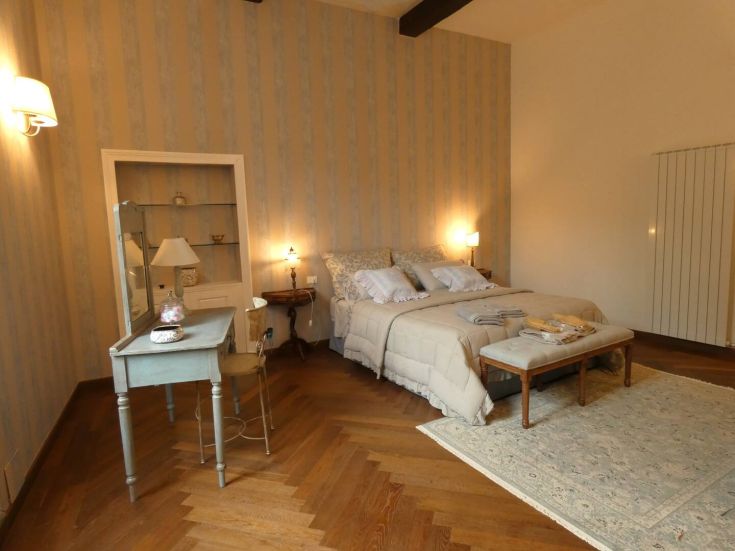 Camera da letto con arredi classici e decorazioni luminose, creando un ambiente confortevole per il riposo.