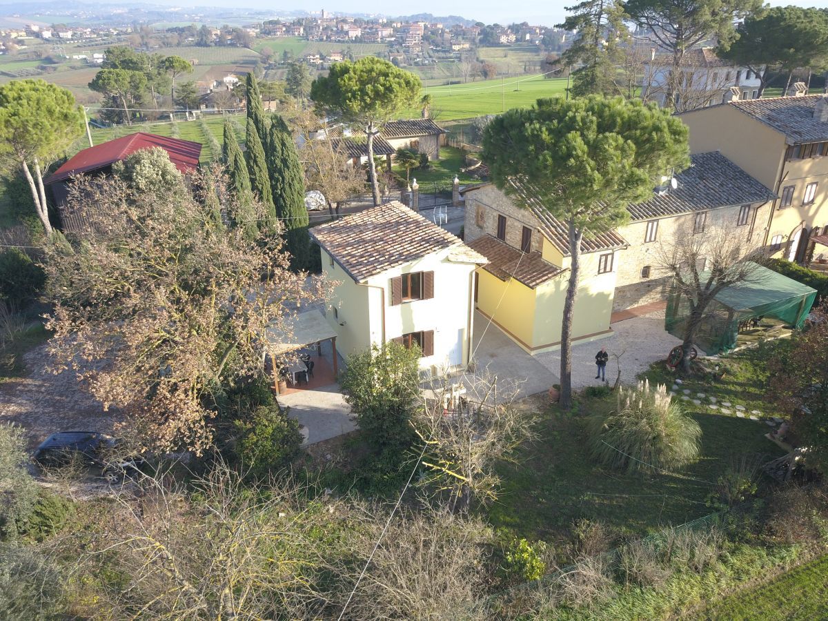 Un edificio immerso nella natura, circondato da alberi e piante, adatto per momenti di relax in Umbria.