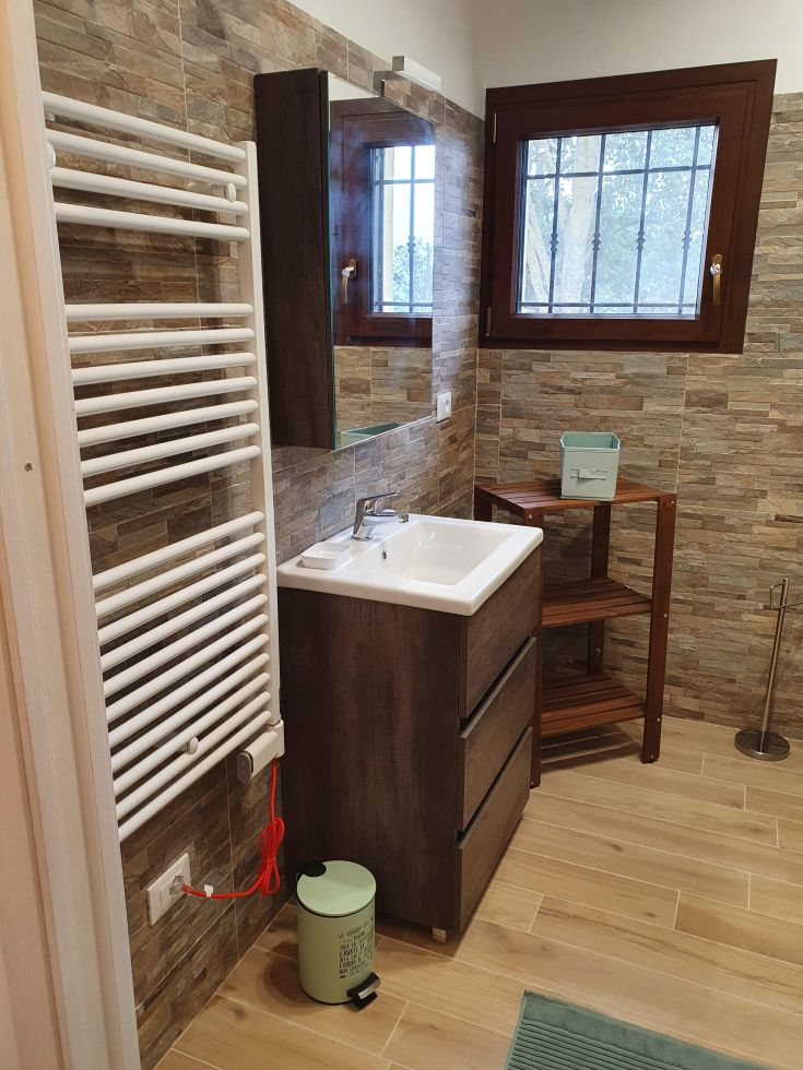 Ein modern eingerichtetes Badezimmer, das sorgfältig gestaltet ist und mit modernen Annehmlichkeiten für Komfort und Funktionalität ausgestattet ist.