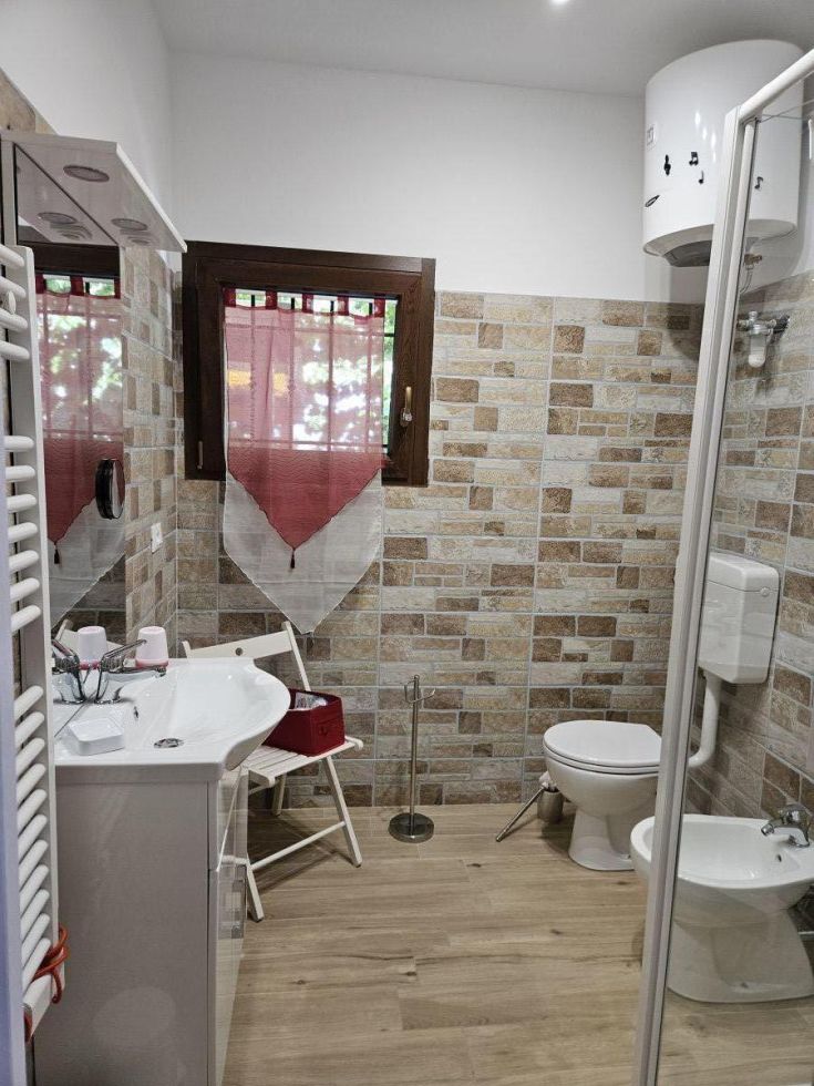 Elegantes Badezimmer mit Steinverkleidungen und guter Beleuchtung.