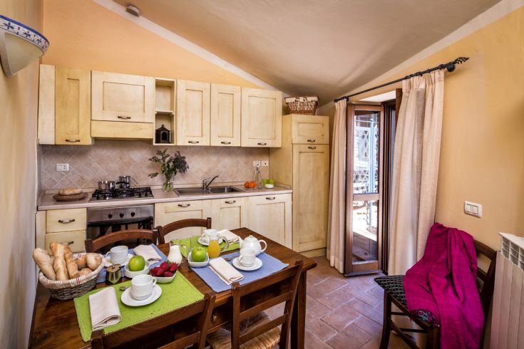 Cucina ben organizzata con tavolo apparecchiato per una colazione variata e invitante.