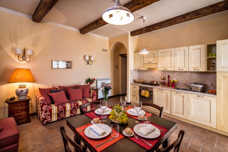 Un soggiorno semplice con angolo cottura, arredato con elementi tradizionali.