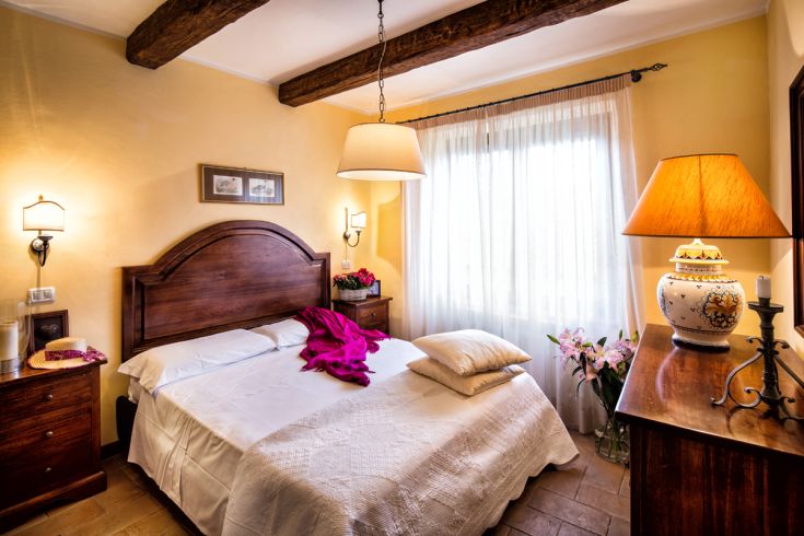 Camera spaziosa con elementi in legno e buona illuminazione naturale, ideale per un soggiorno confortevole.