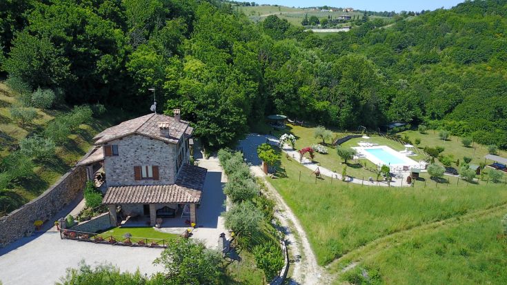 Ein gemütliches Agriturismo, umgeben von Bäumen und Wiesen, mit einem Pool, perfekt für Entspannung und ruhige Spaziergänge.