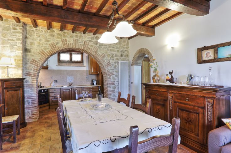 Eine gemütliche Küchenecke mit Steinwänden und einem Tisch, der für gemeinsame Mahlzeiten gedeckt ist.