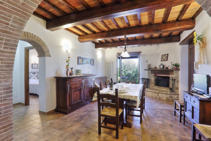 Eine einfache und gemütliche Küche mit einem Tisch und einem Kamin, mit Blick auf eine natürliche Umgebung.