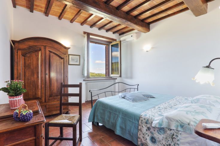 Gemütliches Zimmer mit Holzmöbeln und einem Fenster mit Blick auf eine ruhige Landschaft. Ideal für einen entspannten Aufenthalt.