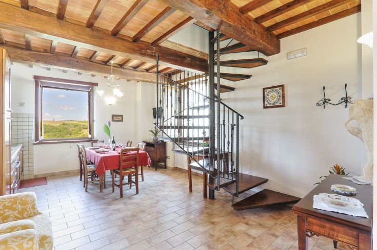 Gemütliches Wohnzimmer mit einer Wendeltreppe und Blick auf einen See, ideal für Momente der Ruhe.