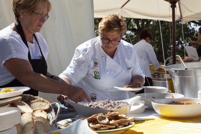 due donne impiattano delle pietanze all'aperto per un buffet 