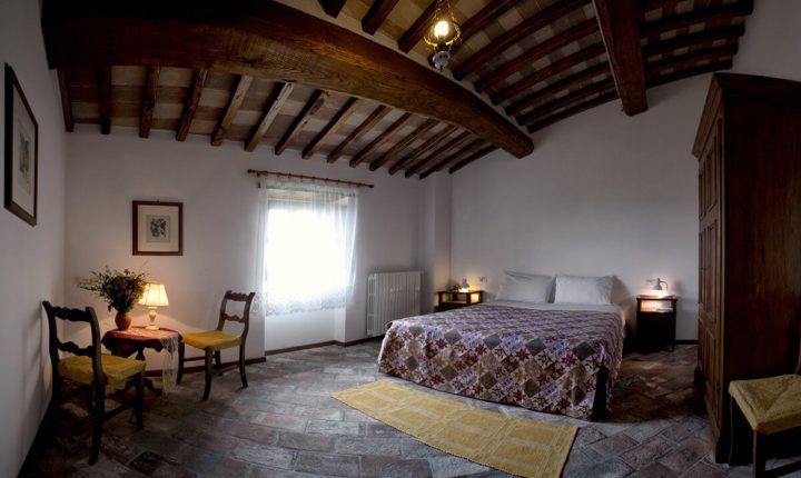 Ein einfaches und einladendes rustikales Zimmer mit bequemen Betten und Holz Möbel, in einer ruhigen Atmosphäre.