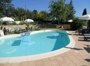 Une piscine confortable entourée de chaises longues et de parasols dans un cadre relaxant.