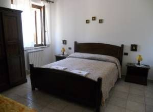 Chambre double sobre avec mobilier en bois et une fenêtre laissant entrer la lumière naturelle.