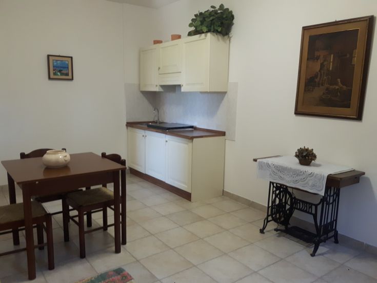 Une cuisine simple et accueillante avec une table, des chaises et une décoration rustique.