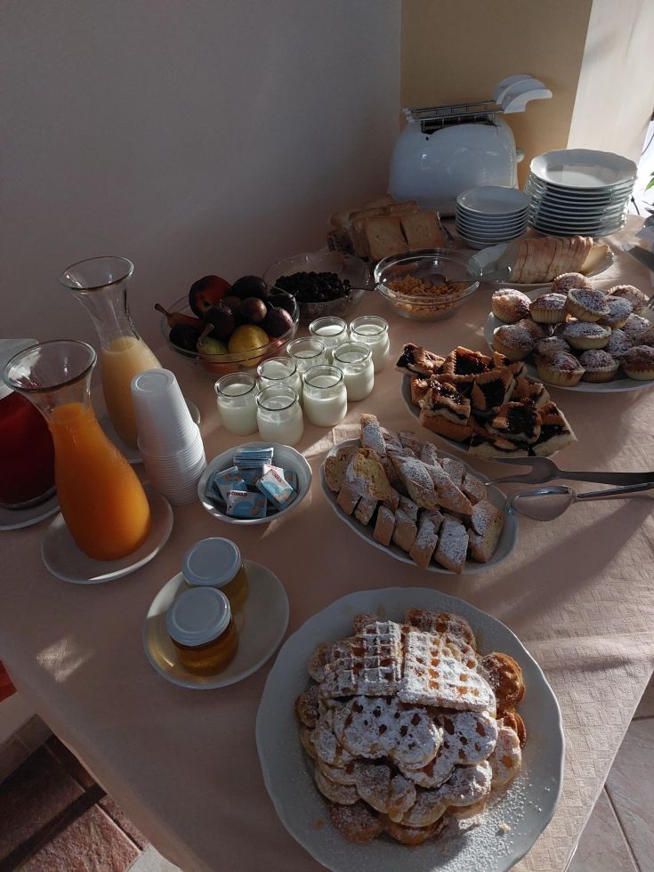 Un buffet avec des pâtisseries, des fruits frais et des boissons pour un petit-déjeuner agréable.