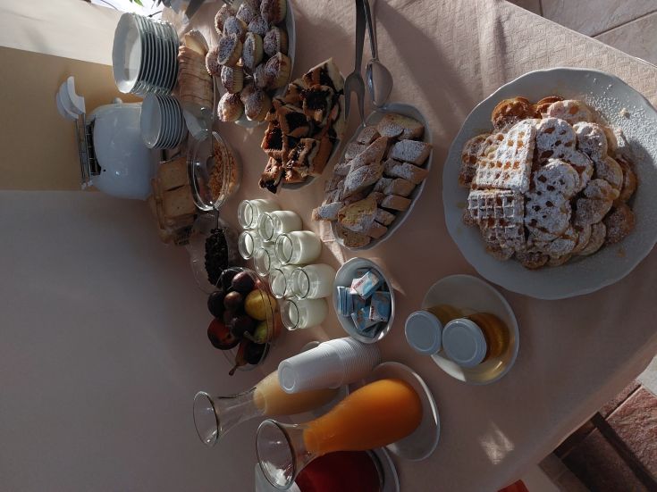 Une table avec une sélection de douceurs, de fruits frais et de boissons, idéale pour un petit-déjeuner copieux.