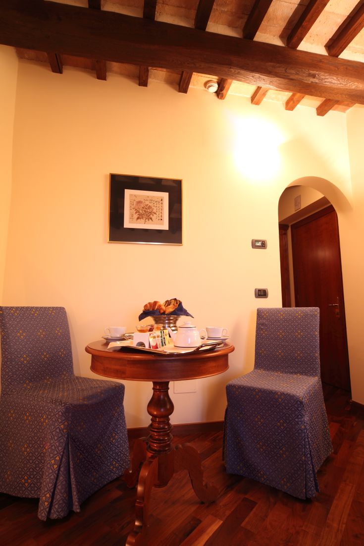 Un espace petit-déjeuner intime avec une table ronde, des chaises simples et de la nourriture fraîche.