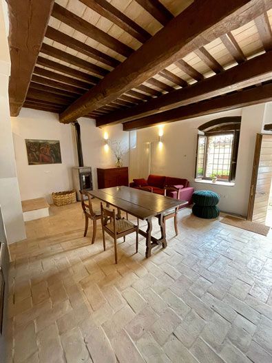 Un soggiorno semplice con travi a vista e un tavolo in legno per i pasti.