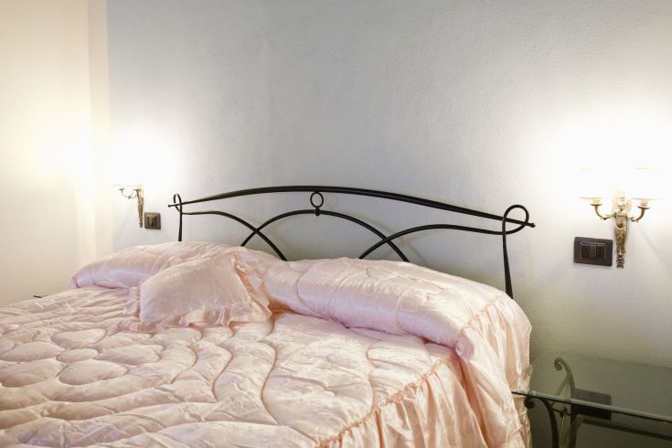 Camera tranquilla con letto matrimoniale e decorazioni in toni chiari.