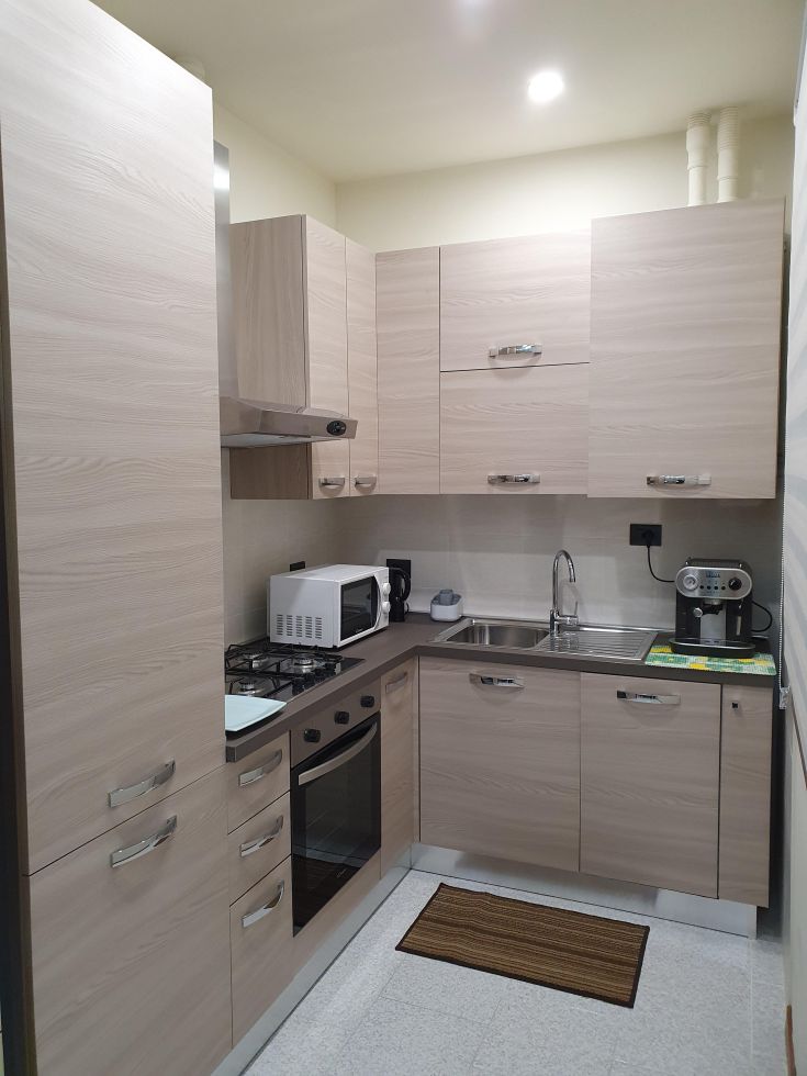 Modern and functional kitchen with light furniture, practical appliances, and well-organized spaces.