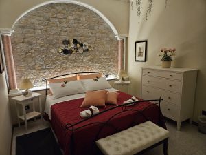 Comfortable bedroom with a stone wall, double bed, and minimalist furniture for a relaxing stay.