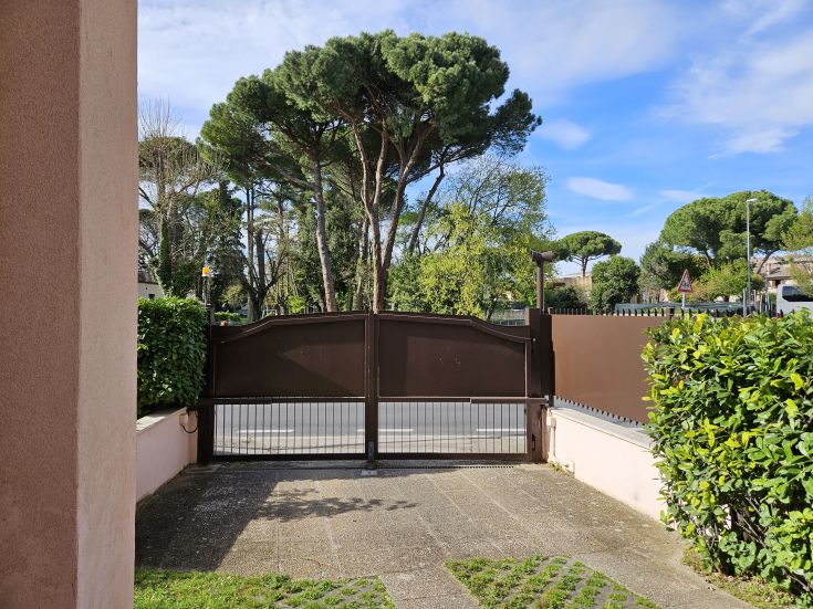 Entrance to an apartment featuring a well-kept garden with a gate. A peaceful environment surrounded by nature.