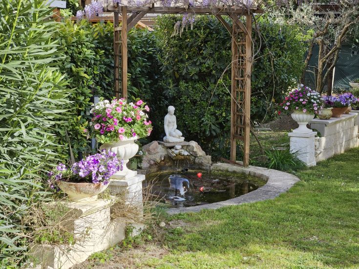A well-maintained garden with colorful flowers and a fountain, perfect for outdoor relaxation.