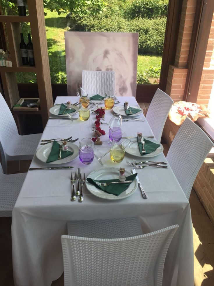 Un tavolo apparecchiato con bicchieri di diversi colori, che crea un'atmosfera accogliente.