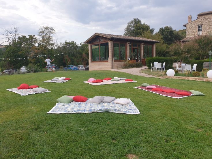 Un'area all'aperto confortevole, con cuscini su tappeti, adatta per momenti di relax.