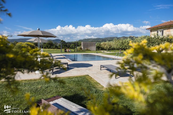 Pool der Tenuta Fogliani, umgeben von grünen Flächen, ideal für Entspannung.