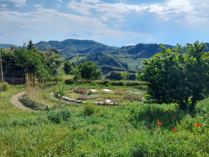 Ein geräumiger Garten, umgeben von sanften grünen Hügeln, perfekt zum Entspannen und Spazierengehen in der Natur.