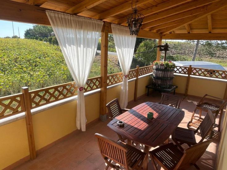 Una terrazza comoda che si affaccia su un ampio campo di girasoli, perfetta per trascorrere momenti di relax all'aperto.