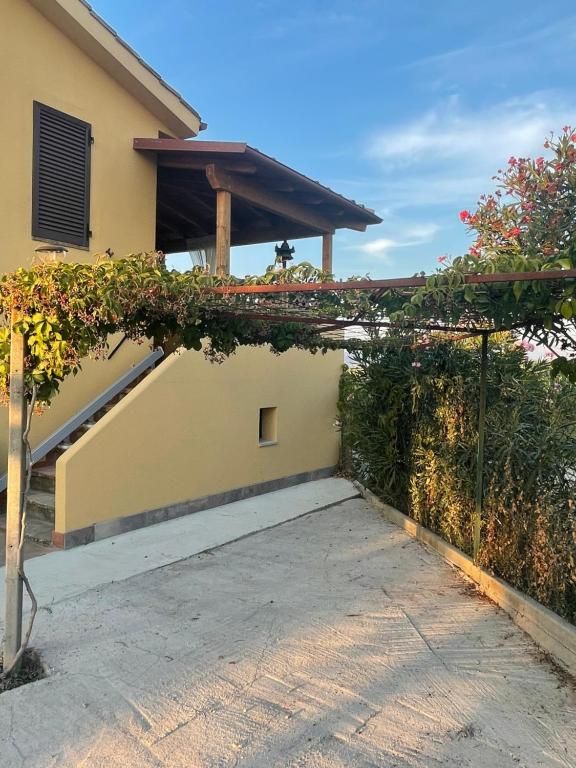 Scena di un'area esterna di un agriturismo, con un sentiero da attraversare circondato da vegetazione.