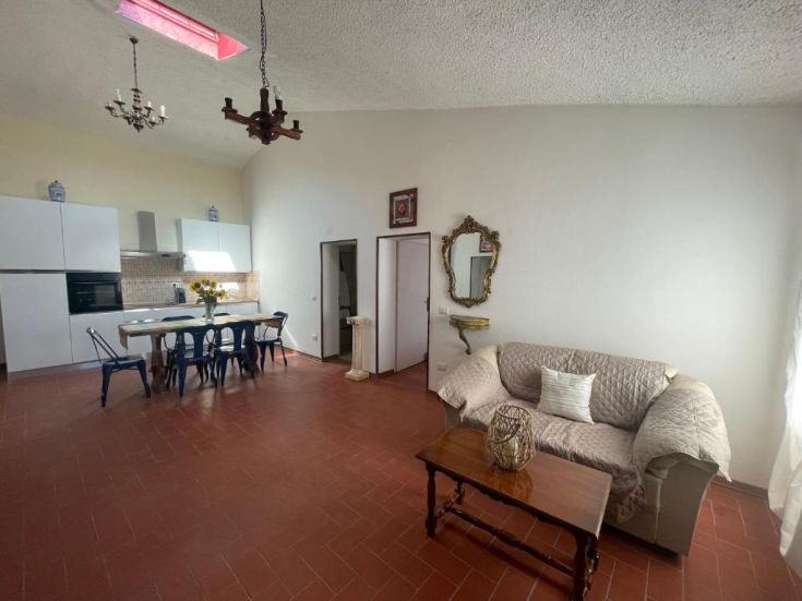 Interno spazioso e luminoso di un agriturismo, con cucina attrezzata e zona soggiorno ben definita.