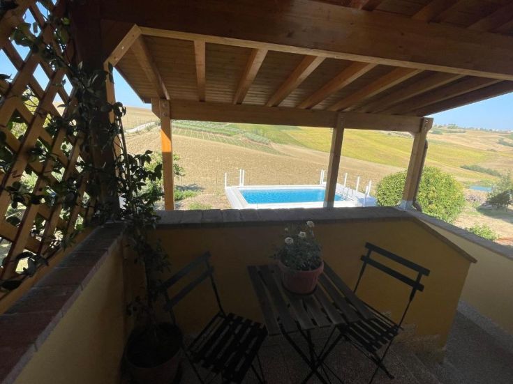 Terrazza con panorama sulla piscina e sulle colline circostanti, ideale per momenti di relax.