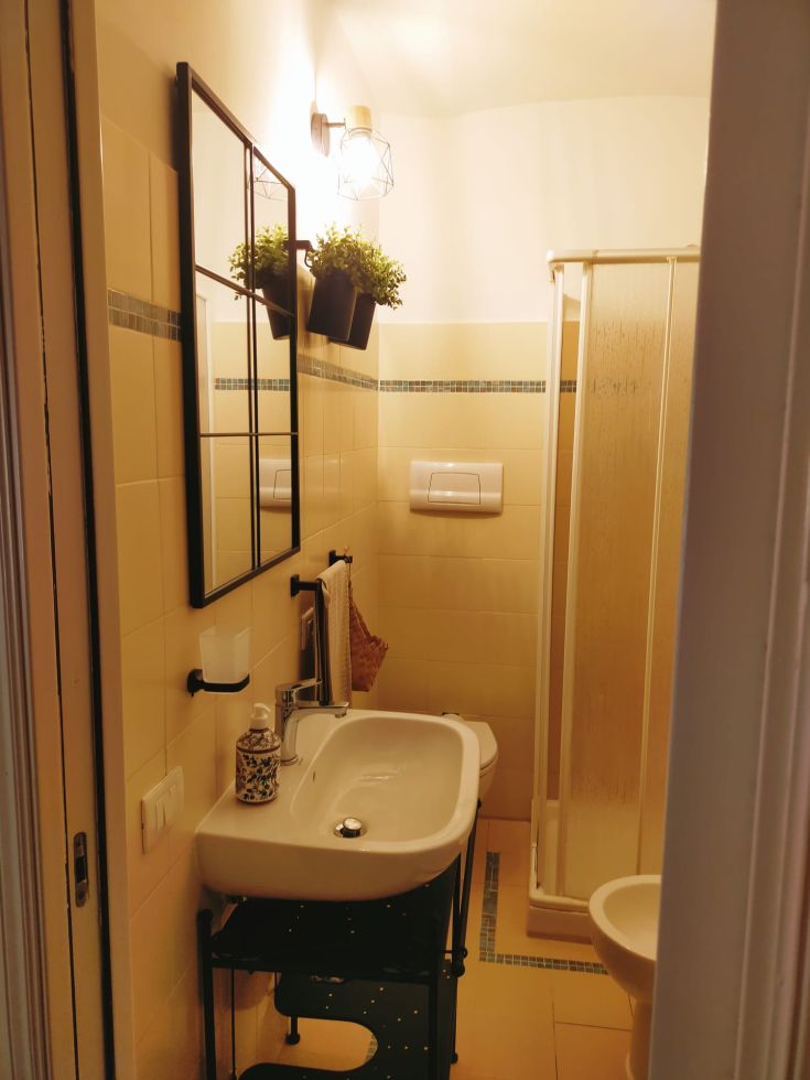 Salle de bain simple et bien meublée, enrichie de détails de design et de plantes vertes.