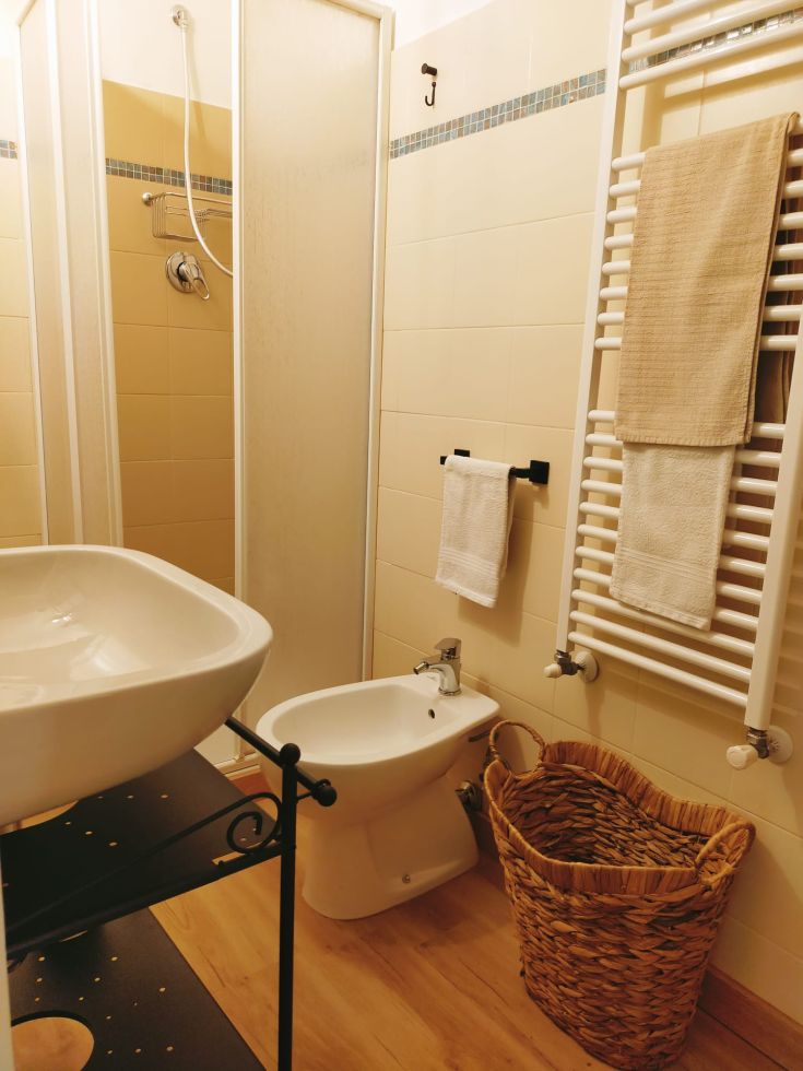 Une salle de bain sobre et fonctionnelle avec douche, lavabo et finitions en bois.