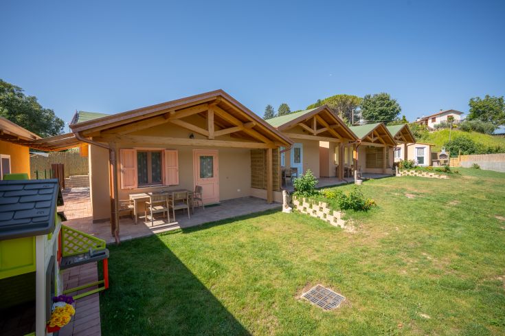 Quatre petites maisons en bois entourées de verdure, idéales pour ceux qui cherchent une escapade dans la nature.