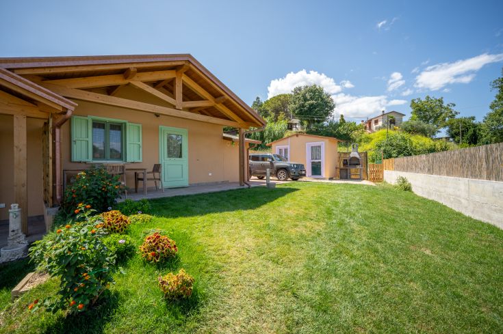 Une scène paisible d'un cottage entouré d'arbres et de fleurs, dans un environnement naturel et relaxant.