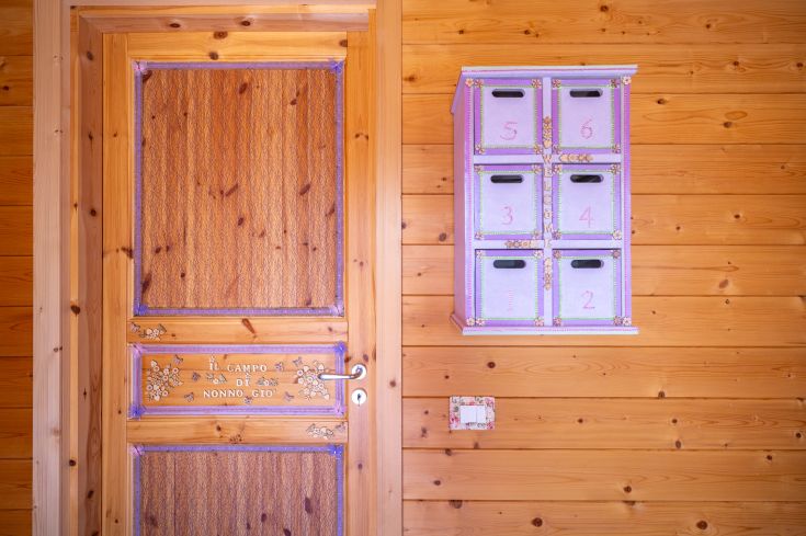 Porte en bois avec tiroirs numérotés dans un environnement simple et accueillant, avec des décorations florales.