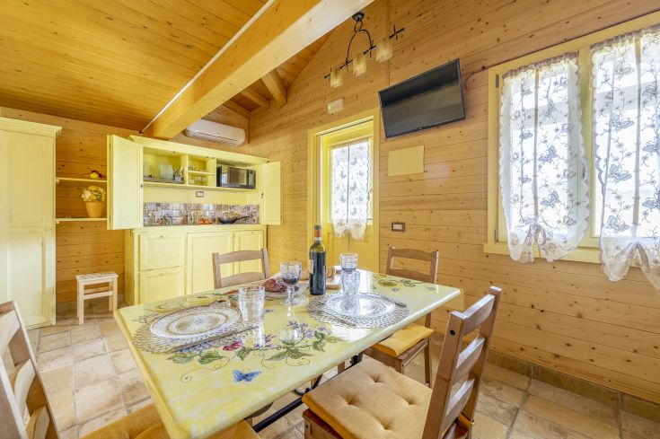 Cuisine en bois simple avec table à manger et décorations colorées.