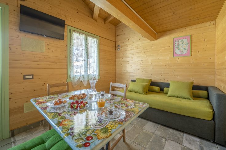 Salon en bois avec une table et un canapé, offrant une ambiance chaleureuse et confortable, idéale pour se détendre.