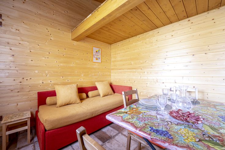 Espace de détente accueillant avec un canapé et une table décorée, idéal pour des rencontres agréables.