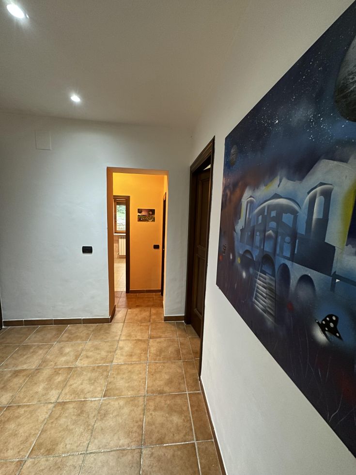 Ingresso ben illuminato, con pareti decorate e un'atmosfera confortevole e accogliente.