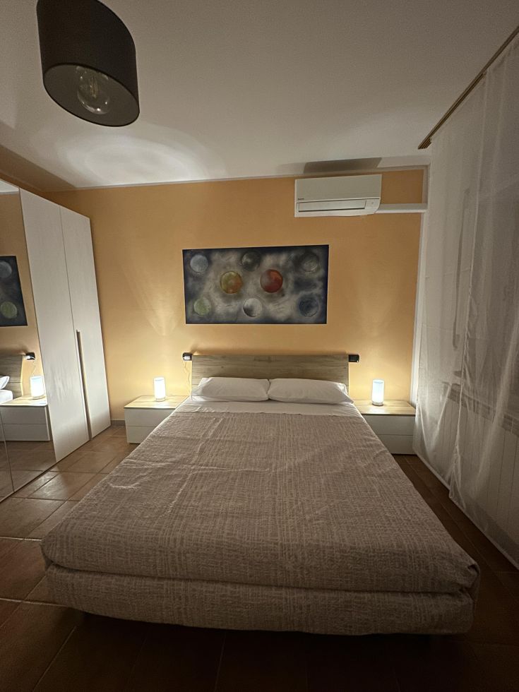 Camera moderna e confortevole con letto matrimoniale, decorazioni alle pareti e luce ambientale.