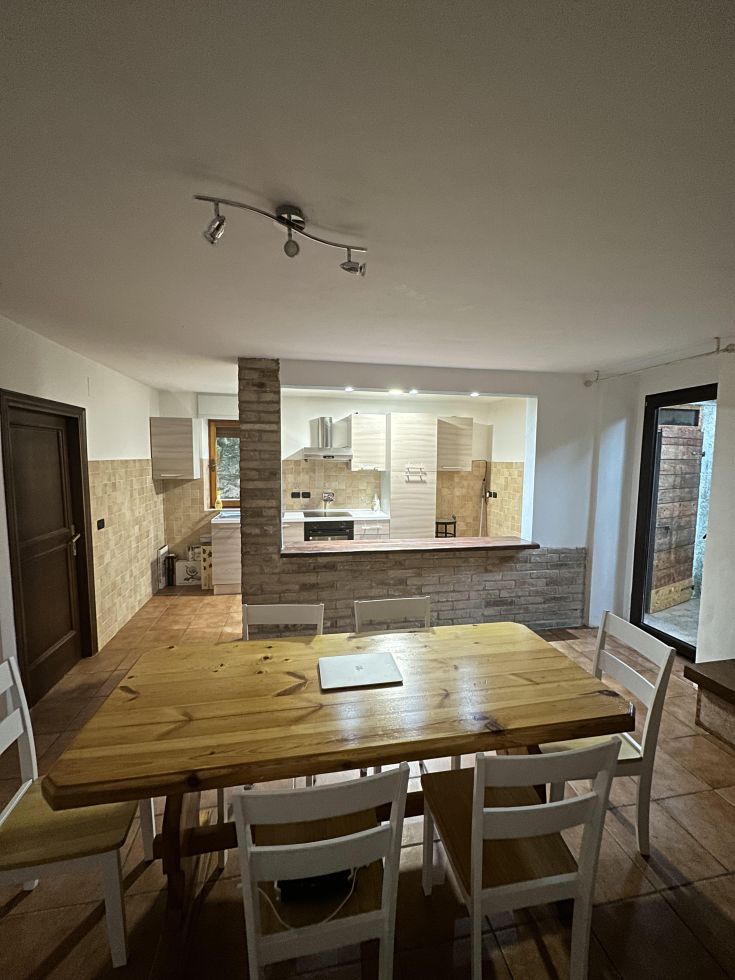 Una cucina moderna e spaziosa con un tavolo in legno, perfetta per momenti di convivialità e relax.