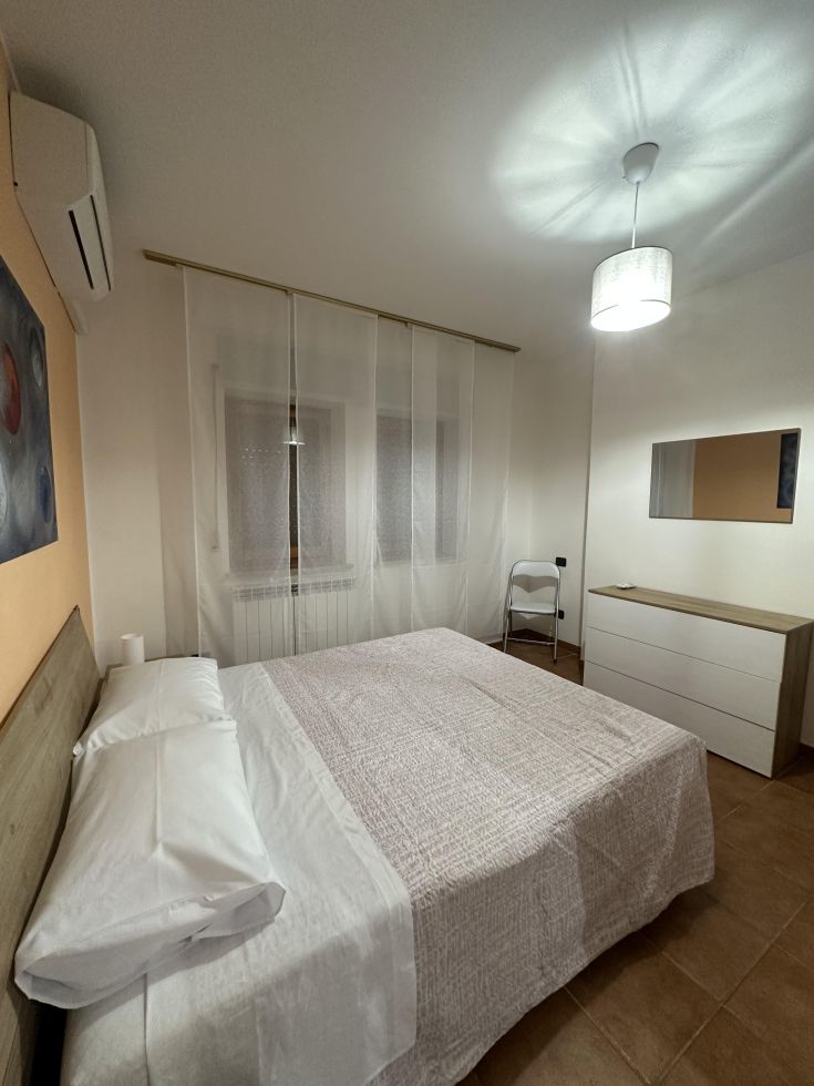 Ambiente tranquillo con letto matrimoniale, dotato di arredi semplici e luminosi.