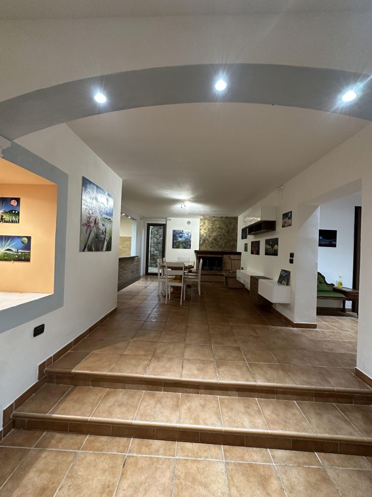 Ambiente interno di un palazzo con cucina e soggiorno, caratterizzato da una decorazione essenziale e funzionale.